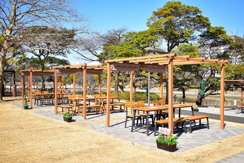 東京都江戸川区 リバーサイドBBQ施設 木目調パーゴラ設置エリア - 川沿いの開放的なBBQスペースに設置された3m×3mのDEPOS木目調パーゴラ。緑豊かな環境で快適なアウトドアダイニング体験を提供