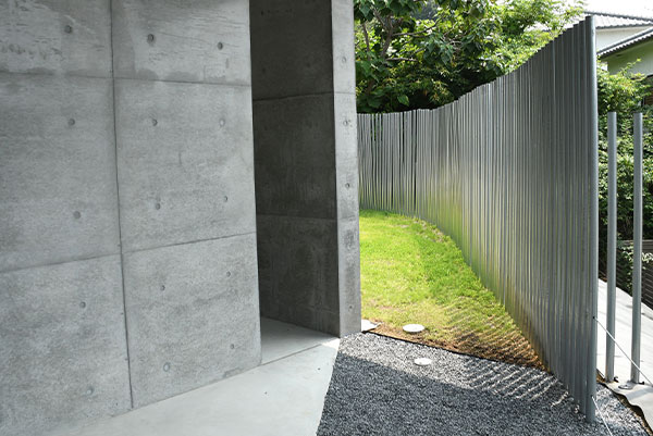 private villa tenの緑に囲まれた芝の築山とアルミフェンスの外構デザイン