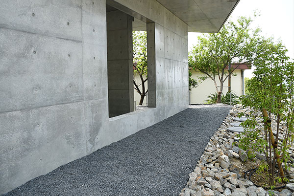 栗石と黒砂利を使ったprivate villa tenの建物沿いの歩行スペースと植栽