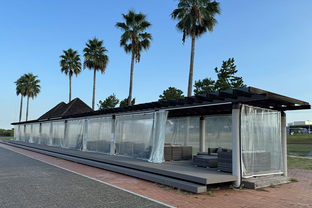 既存パーゴラを改装したBBQガーデン。海沿いに設けた木製デッキと屋外家具。